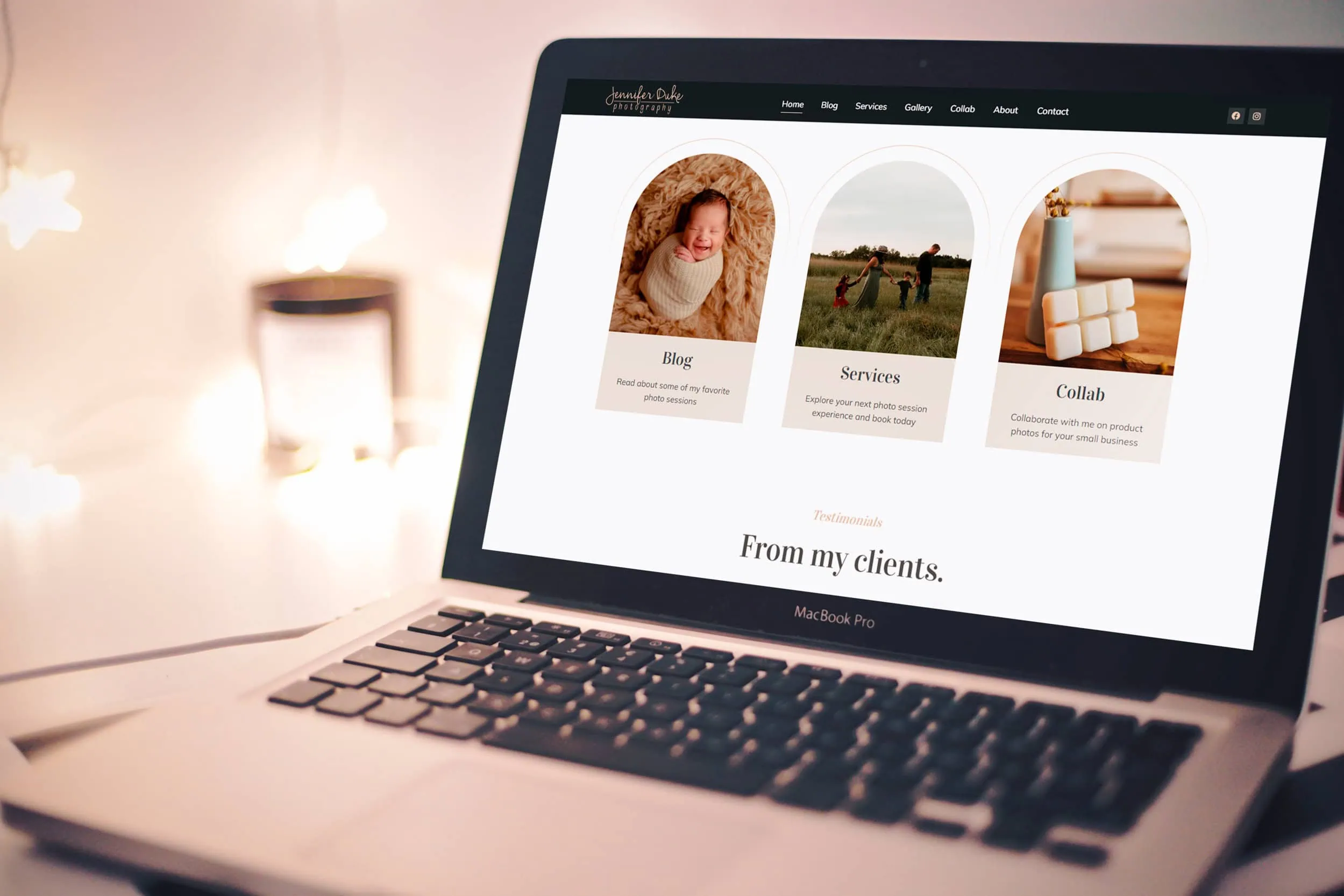 A MacBook Pro on a desk displays a webpage featuring three sections: "Blog" with a photo of a baby, "Services" with an image of a woman in a field, and "Collab" with a close-up of handmade products. The website highlights the artistry of Jennifer Duke Photography against star-shaped lights in the background. - Market Design Team: Define. Structure. Expand.