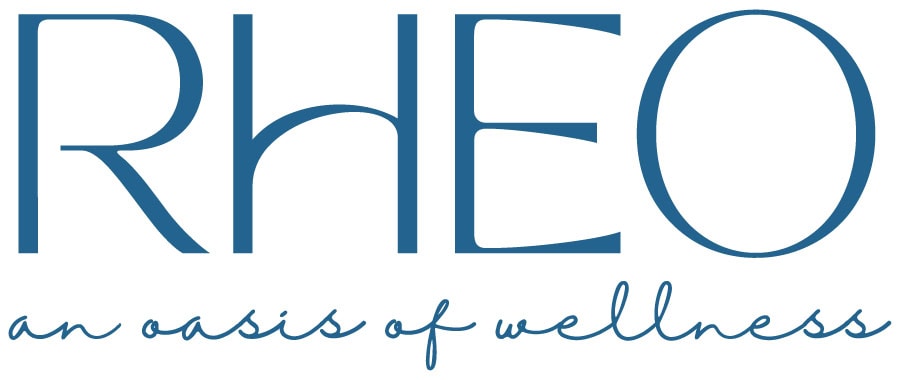 The image shows the word "RHEO" in large blue capital letters above the phrase "an oasis of wellness" in cursive blue text on a white background. - Market Design Team: Define. Structure. Expand.