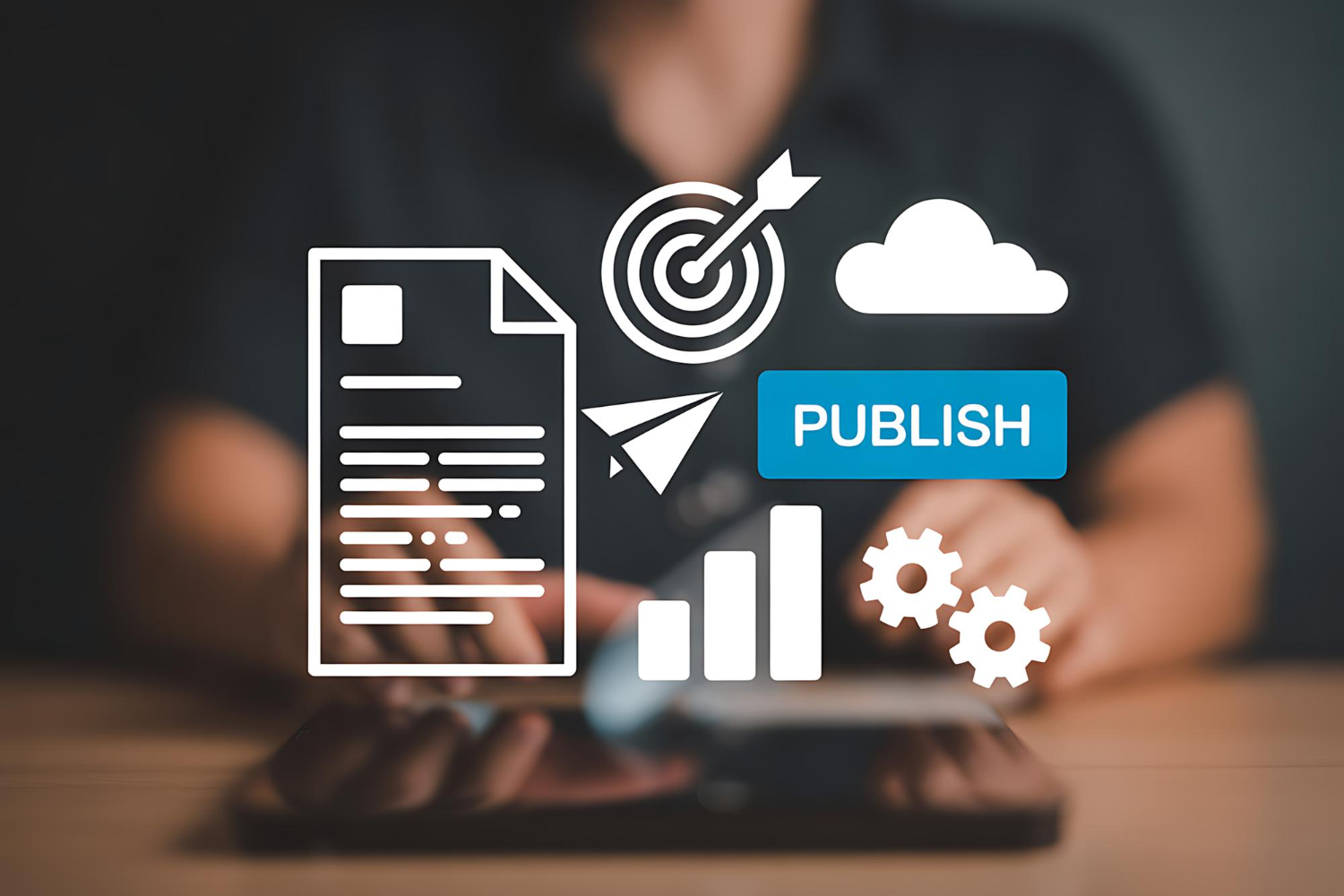 A person uses a tablet, with digital icons overlaid showing a document, target, cloud, "publish" button, and gears&mdash;illustrating content creation and publishing strategies used by content marketing agencies for New Year planning. - Market Design Team: Define. Structure. Expand.