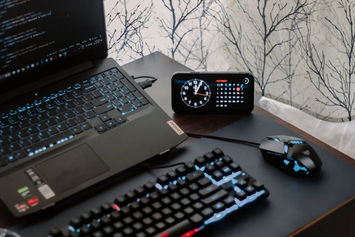 A modern workspace with a laptop, gaming mouse, and keyboard, highlighting the tech-savvy environment for design.