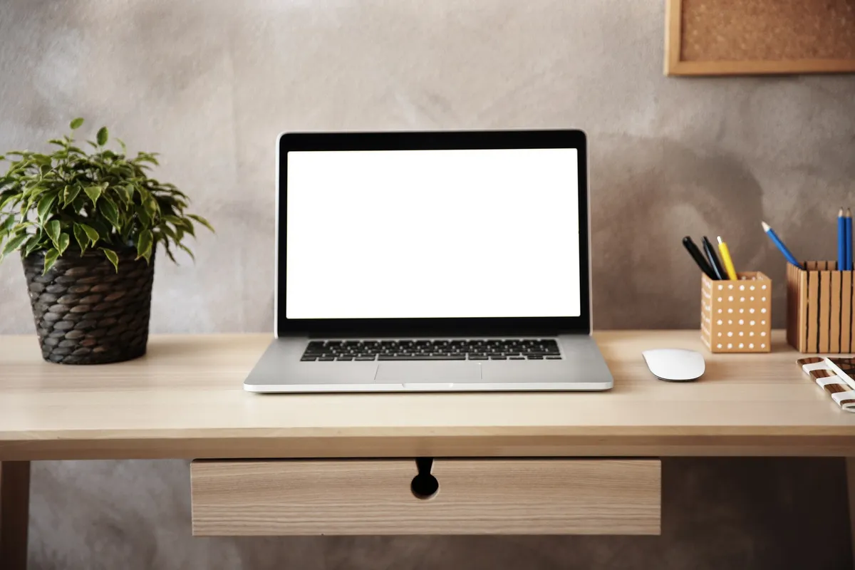 A modern workspace featuring a laptop on a table, symbolizing the importance of affordable website design.